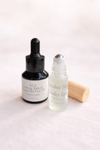 Load image into Gallery viewer, Mini Tulsi face oil and cucumber under-eye roller with fresh basil sprigs, styled as the Green Calm Set by LUX Lifestyle.
